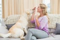 Beautiful blonde relaxing on the couch with pet dog Royalty Free Stock Photo