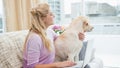 Beautiful blonde relaxing on the couch with pet dog Royalty Free Stock Photo