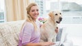 Beautiful blonde relaxing on the couch with pet dog Royalty Free Stock Photo