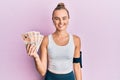 Beautiful blonde sport woman holding 10 united kingdom pounds banknotes looking positive and happy standing and smiling with a