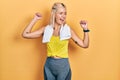 Beautiful blonde sports woman wearing workout outfit dancing happy and cheerful, smiling moving casual and confident listening to Royalty Free Stock Photo