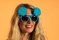 Beautiful blonde in sunglasses posing at the camera. Portrait on the background of bright orange wall. Modern hipster Royalty Free Stock Photo