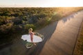 Beautiful blonde surfer girl on her way to the beach on her bicycle with her surfboard. Royalty Free Stock Photo