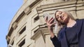 Beautiful blonde talking on the phone with friends, rejoicing, smiling, laughing, white teeth, outdoors close up. The Royalty Free Stock Photo