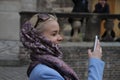 Beautiful blonde teenage girl taking a selfie on smart phone in park. Cute young woman with long hair, smiling, photo Royalty Free Stock Photo