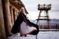 Beautiful blonde Viking dressed in a black cloak against the backdrop of the castle Royalty Free Stock Photo