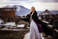 Beautiful blonde Viking dressed in a black cloak against the backdrop of the castle Royalty Free Stock Photo