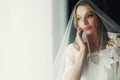 Beautiful blonde wedding bride in make-up and veil in a white dr Royalty Free Stock Photo