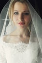Beautiful blonde wedding bride in make-up and veil in a white dr Royalty Free Stock Photo