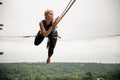 Beautiful blonde woman balancing on a slackline