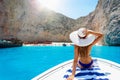 Woman on a boat enjoys the view to the shipwreck beach, Navagio in Zakynthos, Greece