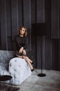 Beautiful blonde woman in a black dress with smoky eye makeup in a loft interior. Soft selective focus Royalty Free Stock Photo