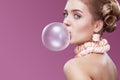 Beautiful blonde woman blowing pink bubble gum. Fashion portrait. Royalty Free Stock Photo