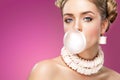 Beautiful blonde woman blowing pink bubble gum. Fashion portrait. Royalty Free Stock Photo