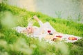 A beautiful blonde woman with a bouquet of flowers is lying on his back a blanket in a meadow near a river on a hill Royalty Free Stock Photo