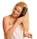 Beautiful blonde woman brushing her hair as a sign og hair care Royalty Free Stock Photo