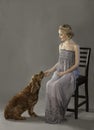 Beautiful blonde woman with cute dog at her feet Royalty Free Stock Photo