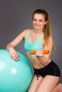 Beautiful blonde woman doing exercises with dumbbells on fitness Royalty Free Stock Photo