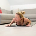 Beautiful blonde woman doing home workout indoors. Woman practice yoga at home. Fit girl using workout tutorials for