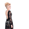 Beautiful blonde woman in elegant black evening dress with updo hairstyle. Lady looking over her shoulder on white Royalty Free Stock Photo