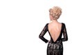 Beautiful blonde woman in elegant black evening low cut back dress with updo hairstyle. Lady looking over her shoulder Royalty Free Stock Photo