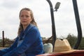 Beautiful blonde woman farmer riding a red tractor to till the soil in order to be able to work in the vegetable garden