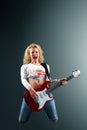 Beautiful blonde woman with a guitar sings a rock song