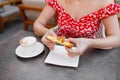 Young woman having italian breakfast with croissant and coffee a