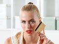 Beautiful blonde woman holding golden credit card Royalty Free Stock Photo