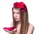 Beautiful blonde woman looking rose petals in her hands Royalty Free Stock Photo