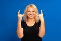 Beautiful blonde woman over blue isolated background screaming with crazy expression doing rock symbol with hands up Royalty Free Stock Photo