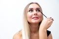 Beautiful blonde woman paints eyelashes. Beautiful female face. Makeup Read More Beauty girl with perfect skin. Makeup