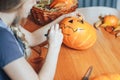 a beautiful blonde woman paints pumpkins for halloween at home on kitchen Royalty Free Stock Photo