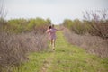 Beautiful blonde woman in pink dress on the road in the garden Royalty Free Stock Photo