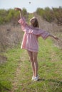 Beautiful blonde woman in pink dress on the road in the garden Royalty Free Stock Photo