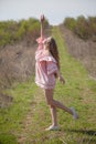 Beautiful blonde woman in pink dress on the road in the garden Royalty Free Stock Photo