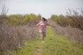 Beautiful blonde woman in pink dress on the road in the garden in the spring Royalty Free Stock Photo