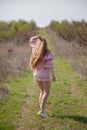 Beautiful blonde woman in pink dress on the road in the garden in the spring Royalty Free Stock Photo