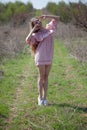 Beautiful blonde woman in pink dress walks through the flowering garden Royalty Free Stock Photo