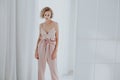 Beautiful fashionable blonde woman in pink silk dress on a white background Royalty Free Stock Photo