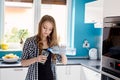 Beautiful blonde woman pouring water from a bottle into a glass. Royalty Free Stock Photo