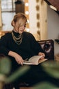 Beautiful blonde woman reads an interesting book in a cozy atmosphere at home. Soft selective focus, defocus, art noise Royalty Free Stock Photo