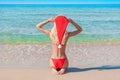 Beautiful blonde woman in red christmas hat on sea beach. Royalty Free Stock Photo