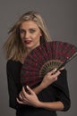 Beautiful blonde woman with red oriental fan Royalty Free Stock Photo