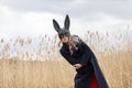Beautiful blonde woman with scared face in black bunny mask