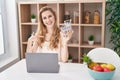 Beautiful blonde woman shopping online with laptop pointing finger to one self smiling happy and proud Royalty Free Stock Photo