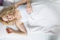 Beautiful blonde woman sleeping in her bed in the morning. Wiev from above