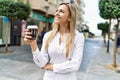 Beautiful blonde woman smiling happy outdoors on a sunny day drinking a take away cup of coffee Royalty Free Stock Photo