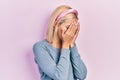 Beautiful blonde woman standing over pink background with sad expression covering face with hands while crying Royalty Free Stock Photo