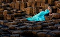 Beautiful blonde woman in turquoise long dress at Giants Causeway in North Ireland Royalty Free Stock Photo